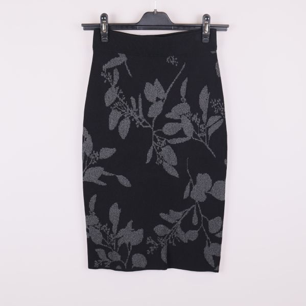 Framsidan av svart pennkjol med grått bladmönster