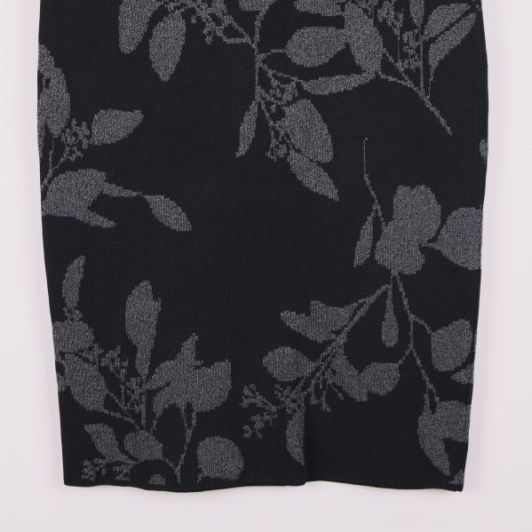 Närbild på nedre delen av kjolen med grått bladmönster