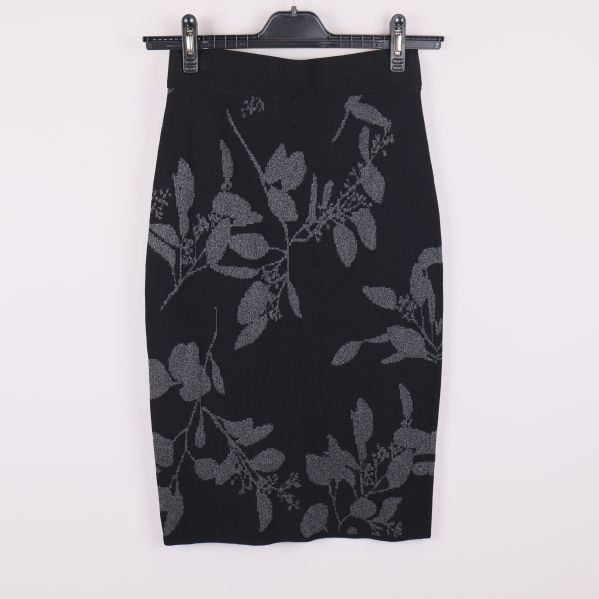 Baksidan av svart pennkjol med grått bladmönster