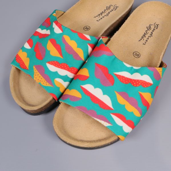 Närbild på sandaler med färgglada läppar på ovandelen