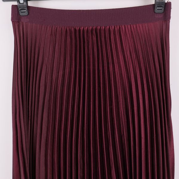 Närbild av plisserad kjols överdel och resårmidja