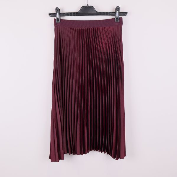 Vinröd plisserad kjol fotograferad bakifrån på galge