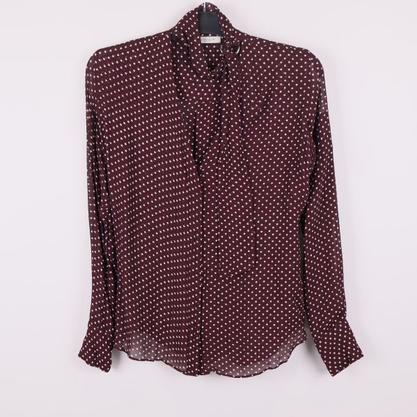 Framifrån av vinröd blus med vita stjärnor och knytband