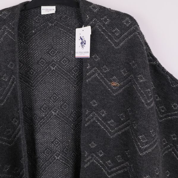 Detaljbild på poncho framtill samt hängande varumärkestagg