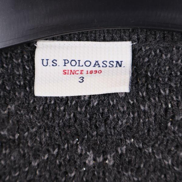 Närbild på varumärkestagg U.S. Polo Assn. i ponchons hals