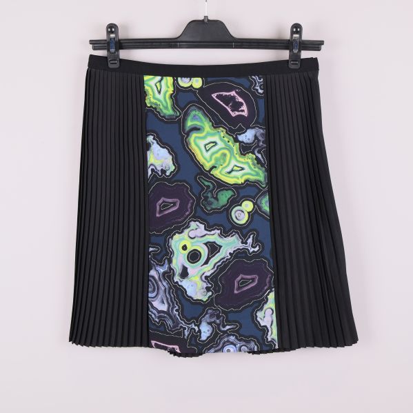 Kjol med svart plissering och färgglad mönstrad panel framtill