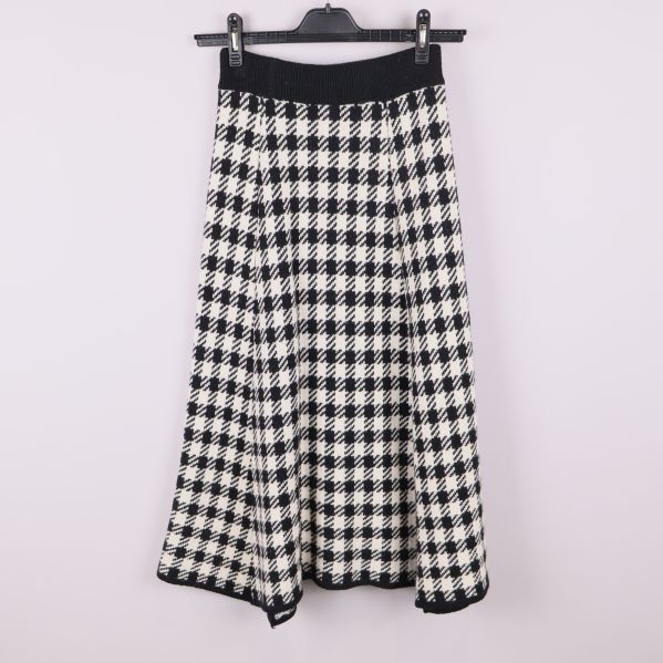 Baksidan av stickad kjol med fiskbensmönster