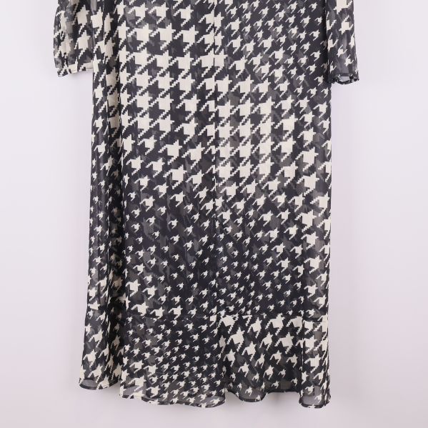 Nederdelen av svartvit långklänning med mönster