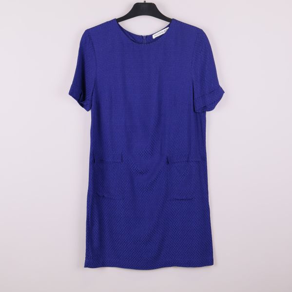 Framsida av blå strukturerad klänning på galge