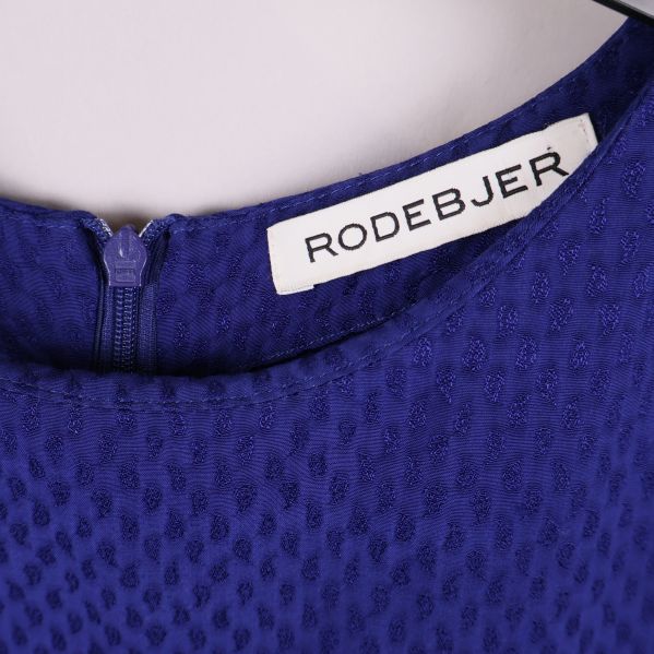 Närbild på Rodebjer-etikett och dragkedja i hals