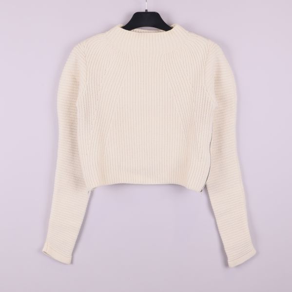 Baksidan på krämvit ribbstickad tröja med lång ärm