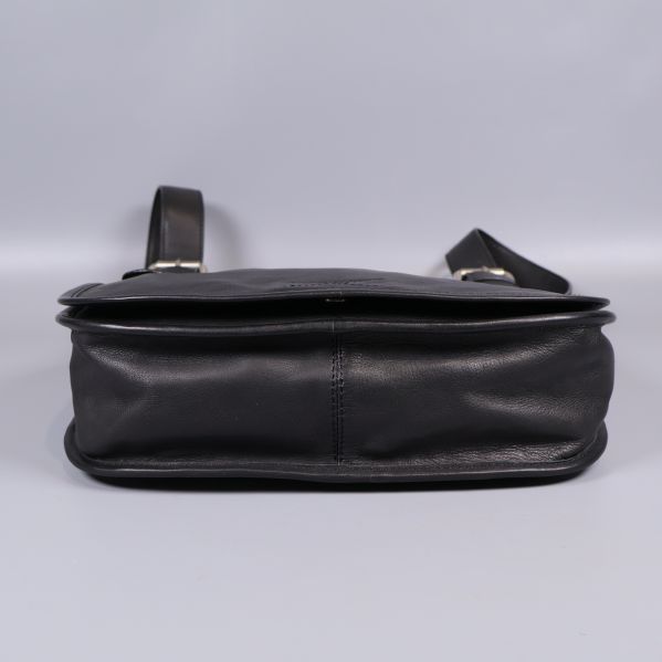 Svart läderväska sedd underifrån på ljus bakgrund