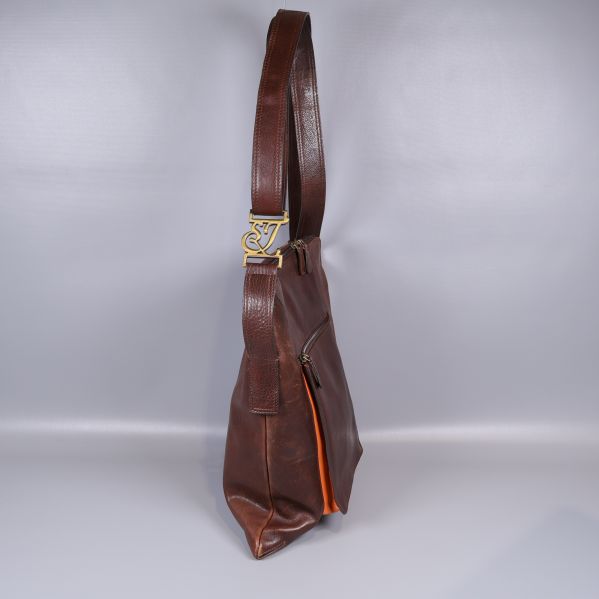 Brun axelremsväska sedd från sidan med bred rem