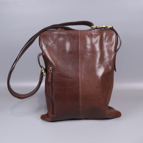Baksidan av brun axelremsväska i läder