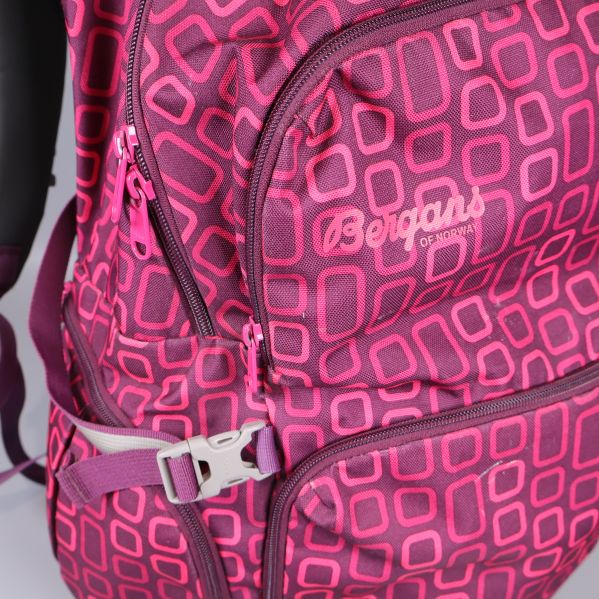 Närbild på ryggsäckens logotyp och dragkedja