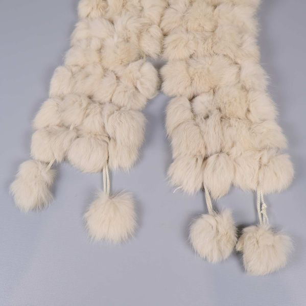 Närbild på tofsar i ändarna av halsduken