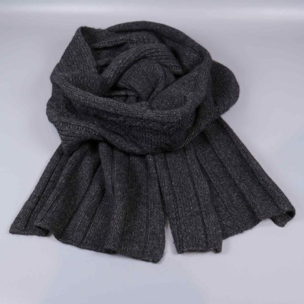Grå ribbstickad halsduk liggande hopvikt