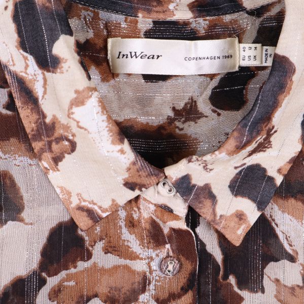 Närbild på krage och knäppning med märkesskylt