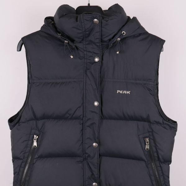 Framdetalj på mörk vadderad väst med tryckknappar