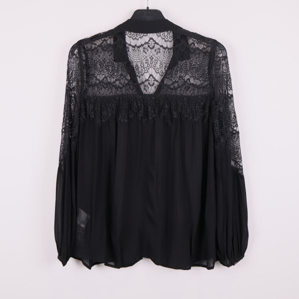 Baksida av svart blus med transparent spets
