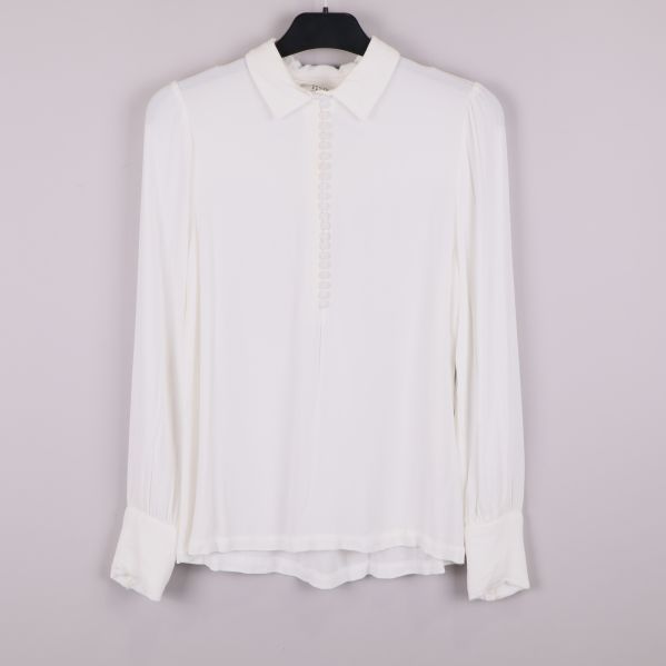 Framsida av vit blus med knappar och krage