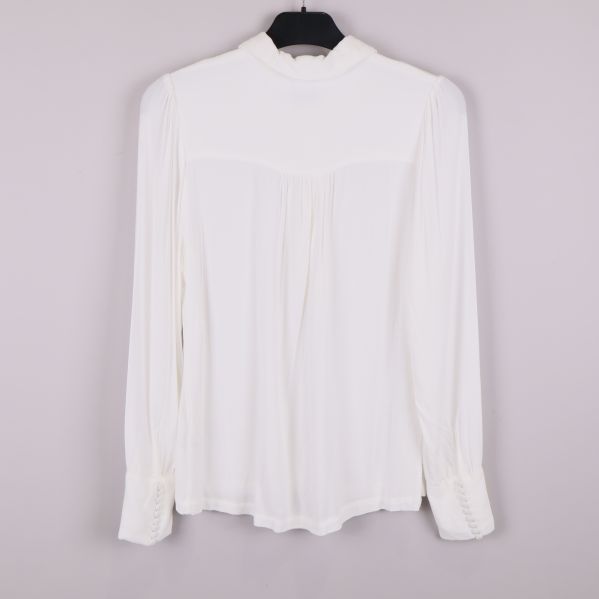 Baksida av vit blus med lätt rynkat ok