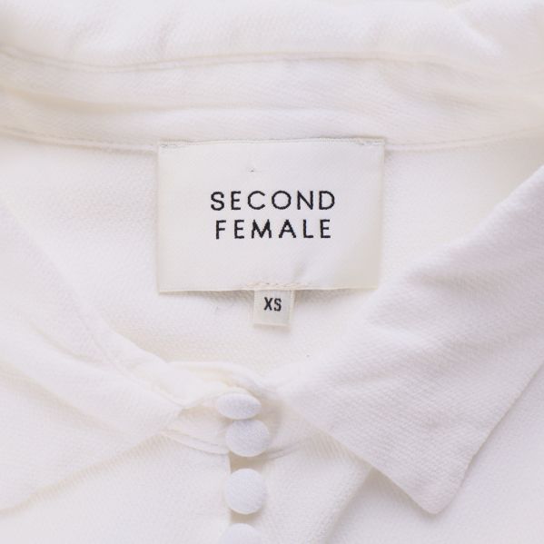 Närbild av Second Female-märke och knappar