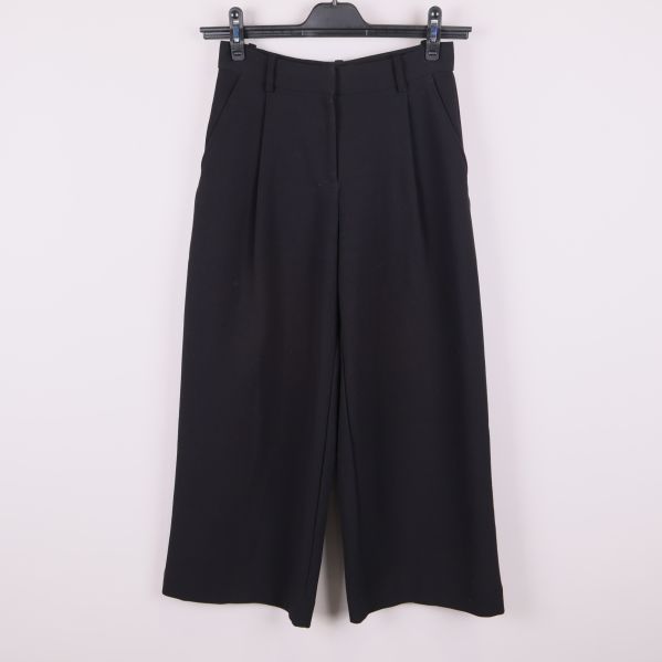 Framsidan av svarta vida kostymbyxor 