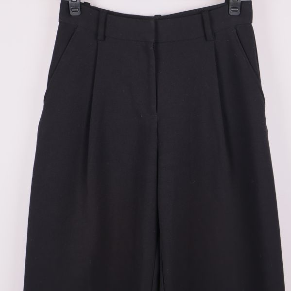 Framdelen av byxorna med synliga fickor och pressveck