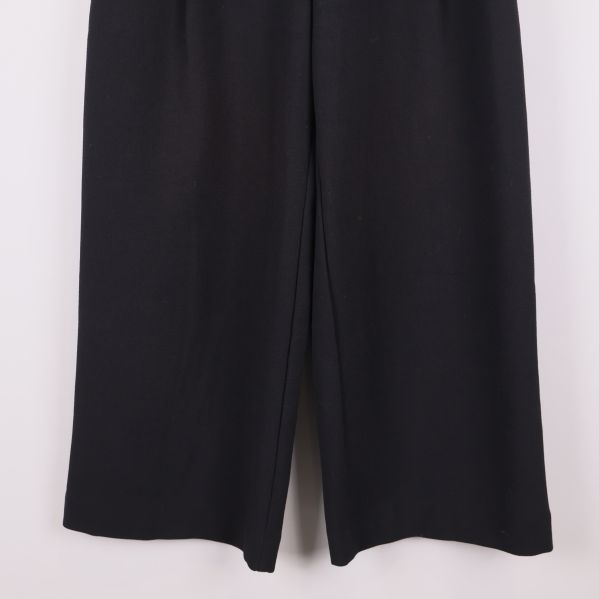 Nederdelen av vida svarta byxor och benslut