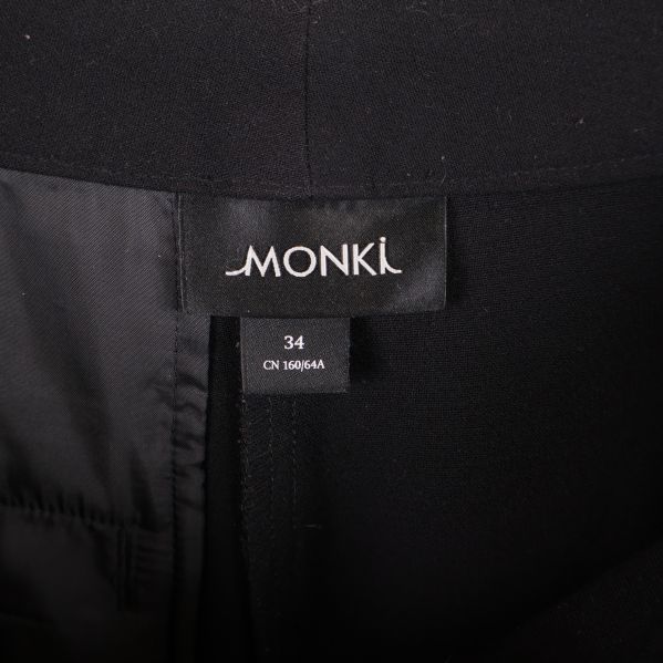 Närbild på Monki-etikett samt storlek 34 i byxorna