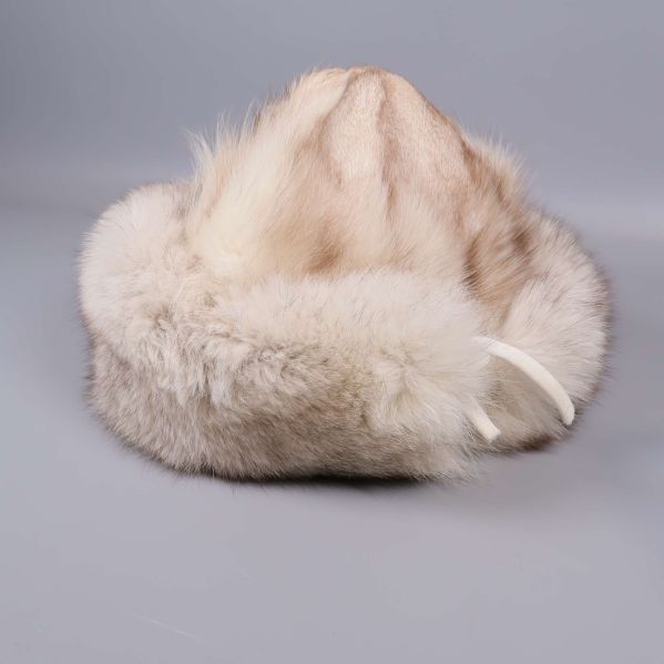 Närbild på mössa i ljus päls och knytband