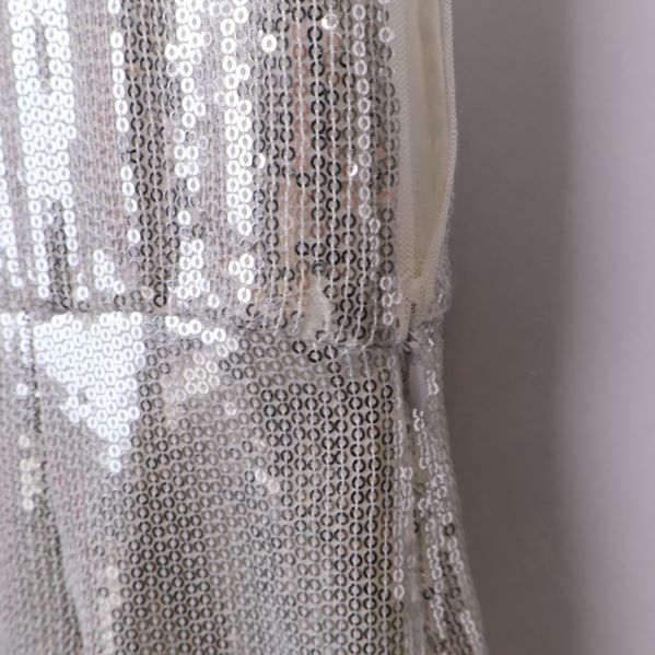 Sidsöm och paljettkant på vit klänning