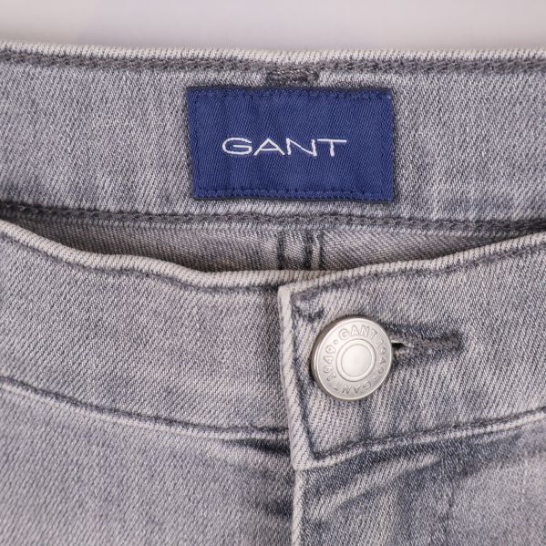 Närbild på jeansens linning med blå Gant-märke