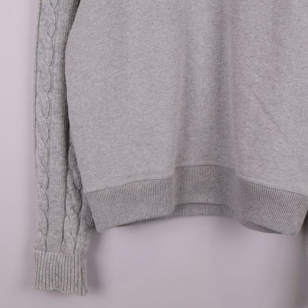 Närbild på tröjans nederkant och mudd i grått