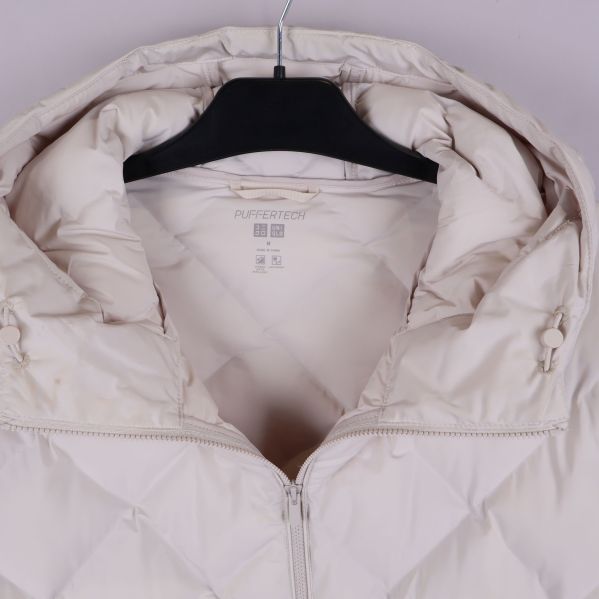 Närbild på huva och krage av quiltad jacka