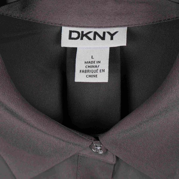 Närbild på DKNY-logotyp i nacken av skjorta