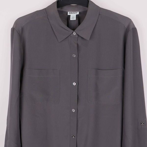 Närbild på skjortans knäppning och bröstfickor