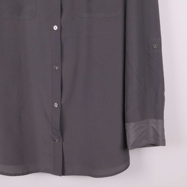 Nedre delen av skjorta visar manschett och knappar