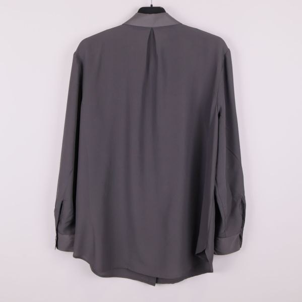 Baksida av grå skjorta med veck i ryggen