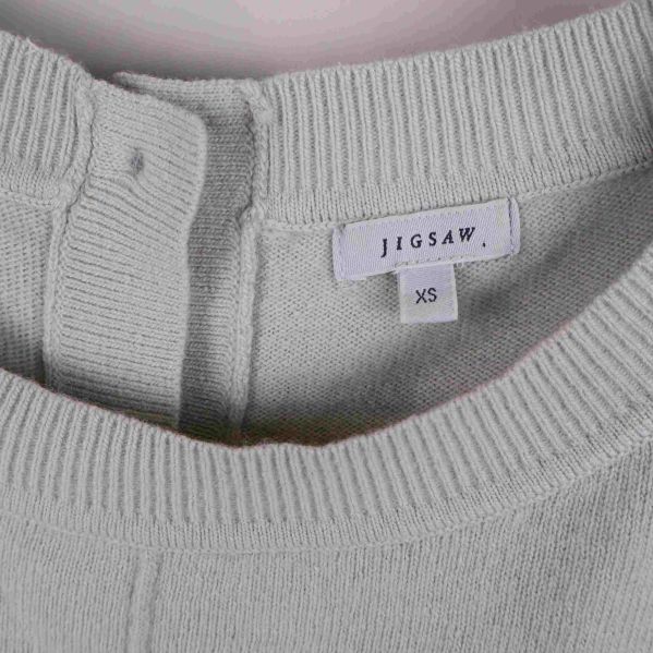 Närbild på Jigsaw-märkesetikett och storlek XS