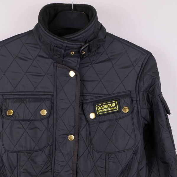 Ficka, etikett och krage i närbild på quiltad jacka