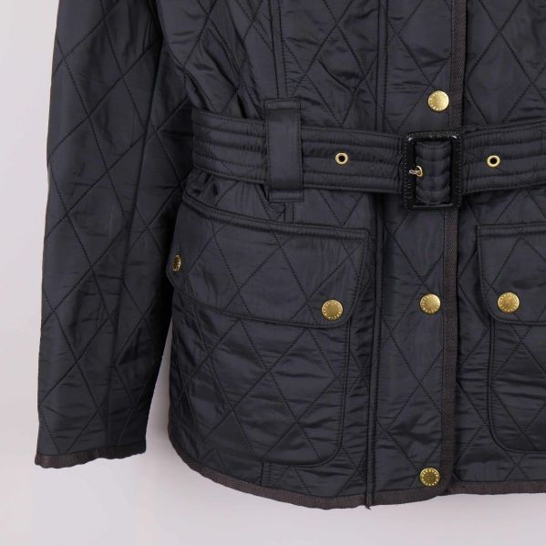 Nedre del av svart jacka med fickor och bälte