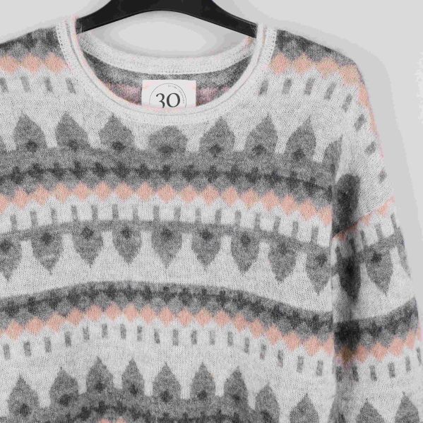 Övre del av stickad tröja med rund hals och mönster