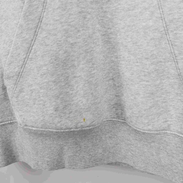 Närbild av känguruficka och nederkant på ljusgrå hoodie