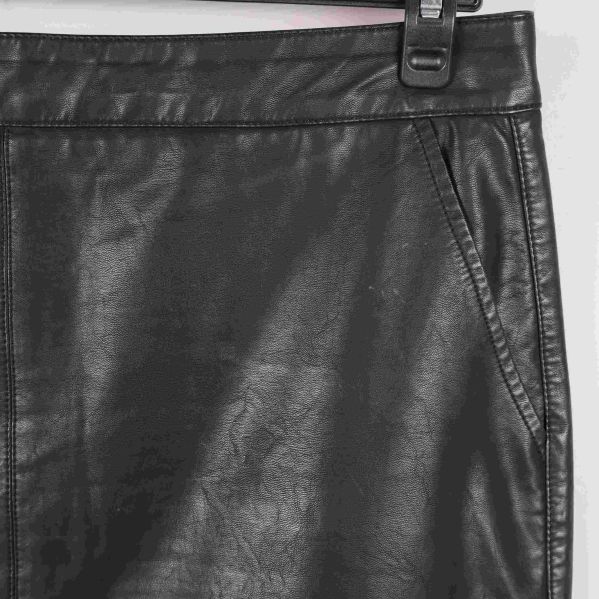 Närbild på ficka och söm på svart konstläderkjol