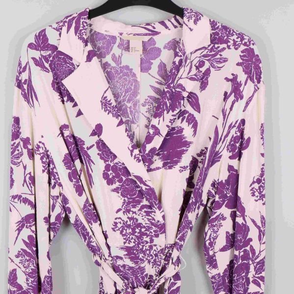 Närbild på omlottblusens krage och överdel med lila blommönster