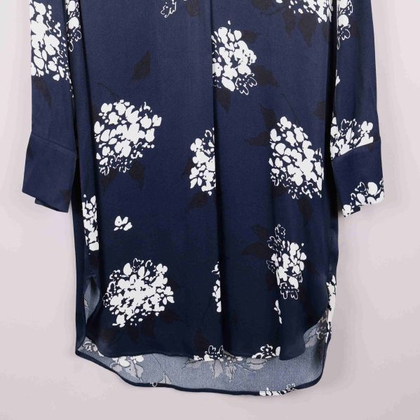 Nedre del av klänning, visar rundad fåll och blommönster