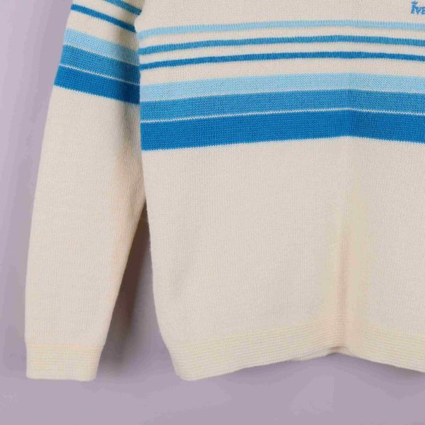 Närbild på vänster ärm och tröjans randiga detaljer