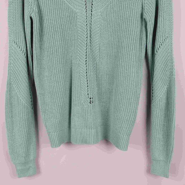 Närbild på tröjans nedre framdel och ärmslut